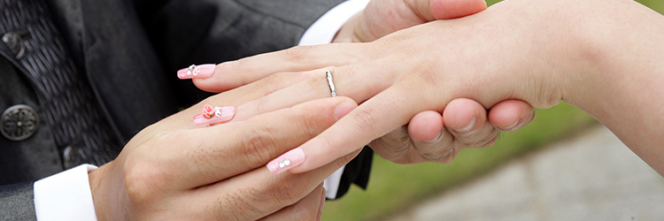 結婚指輪を指に通してもらう女性